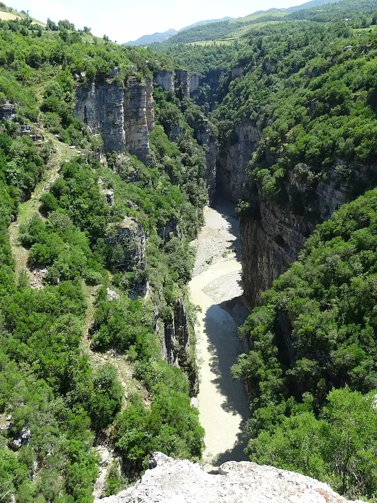 Looking straight down into a narrow section of Osumi Canyon with the pale river between vertical walls