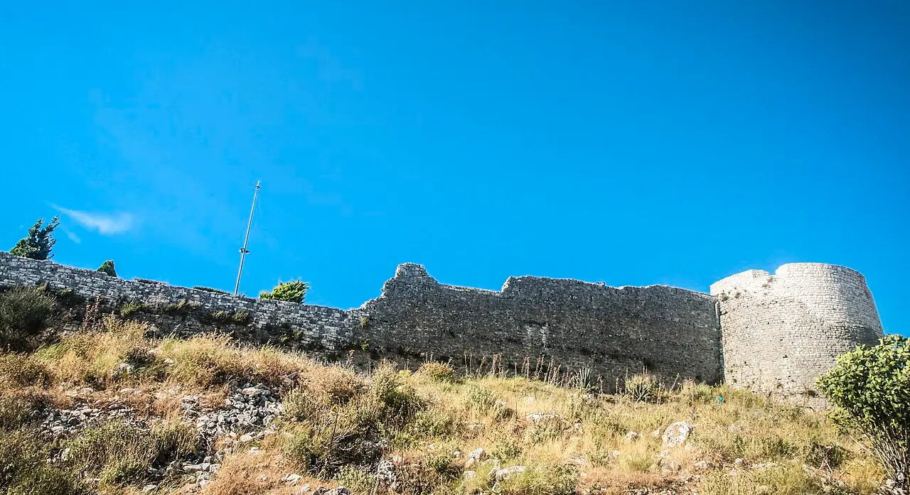 The ruined stone walls of Lëkurësi Castle on the hill above Saranda