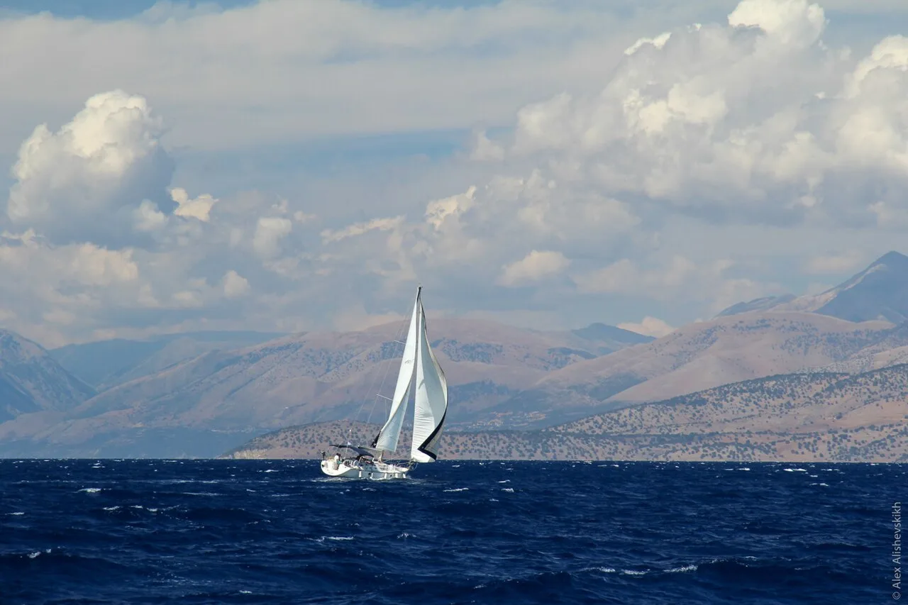 The Albanian Ionian coast seen from a boat with misty hills and deep blue water