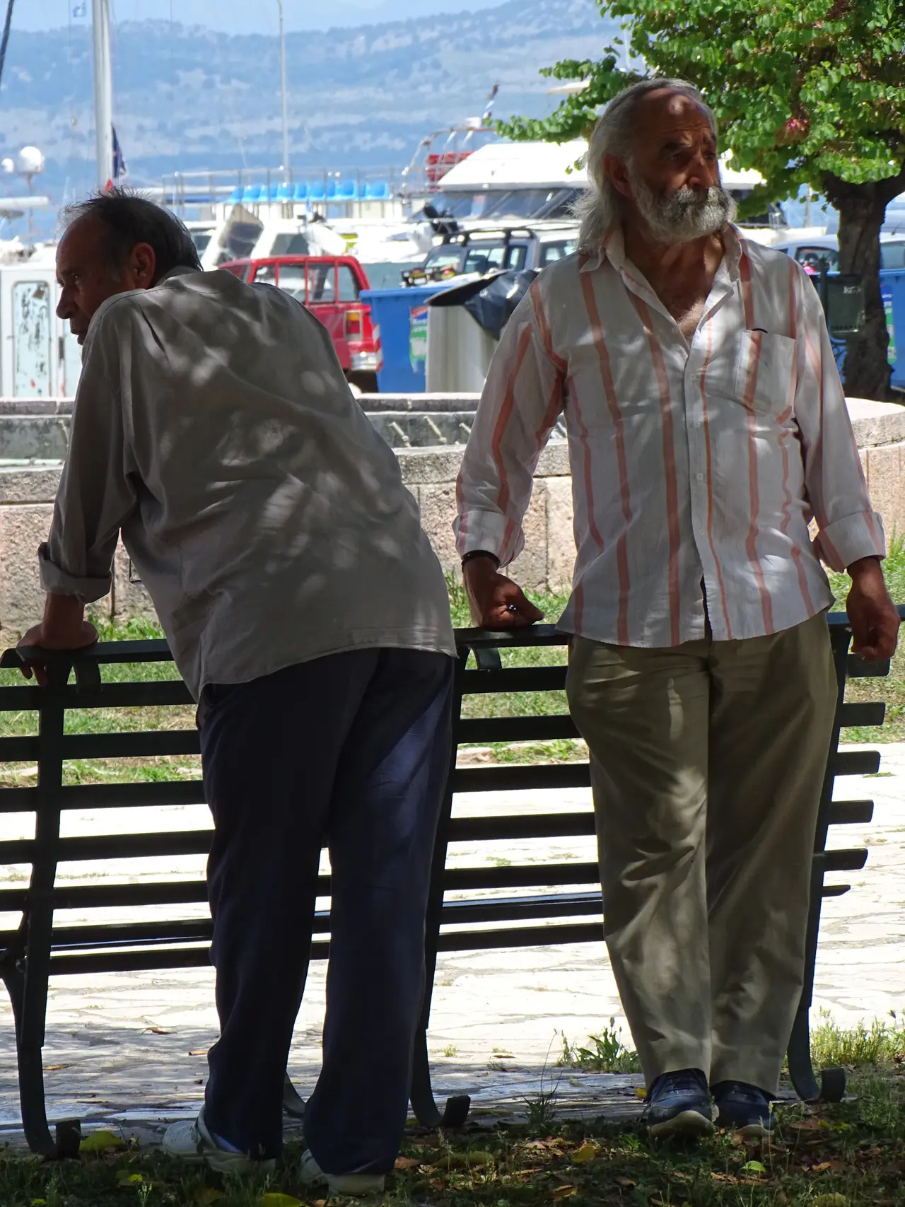 People walking along the Esplanade in Corfu Old Town, Greece, with arcaded buildings behind