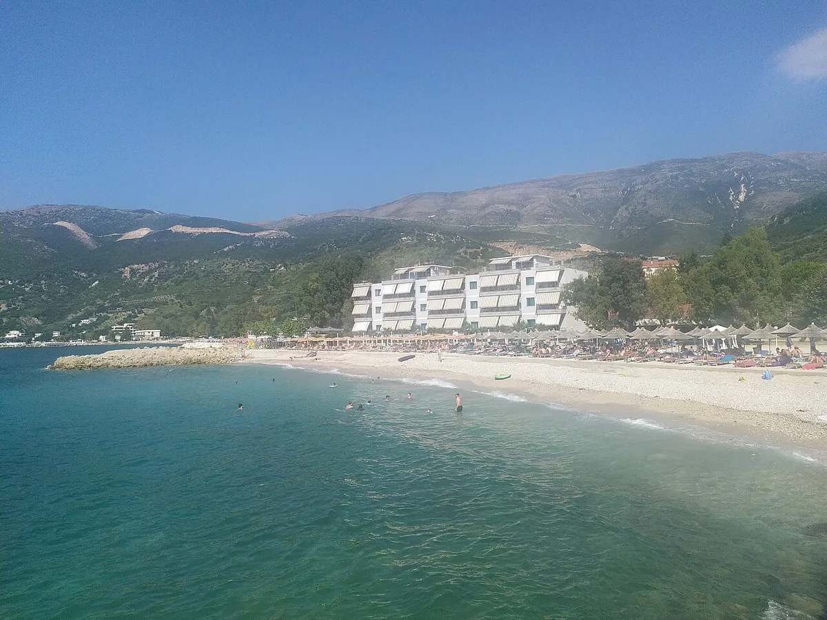 The clear water and pebble shore at Radhime just south of Vlora, backed by hills