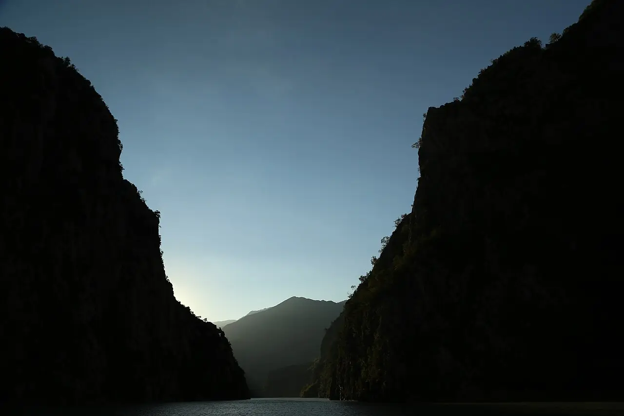 Steep forested walls closing in on the emerald water of Lake Koman on the boat ride toward Shala