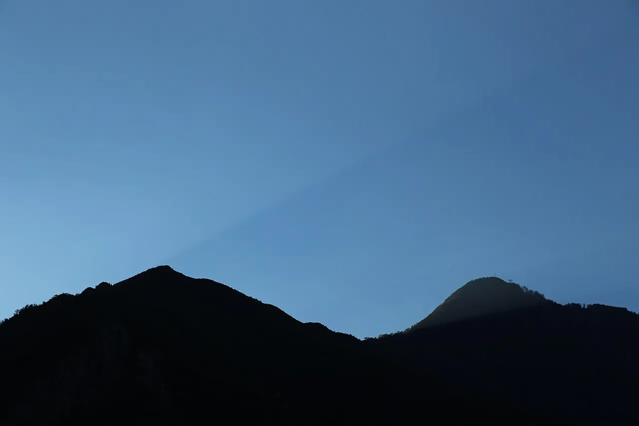 Ridge silhouettes above Lake Koman at first light, the last sun catching one summit