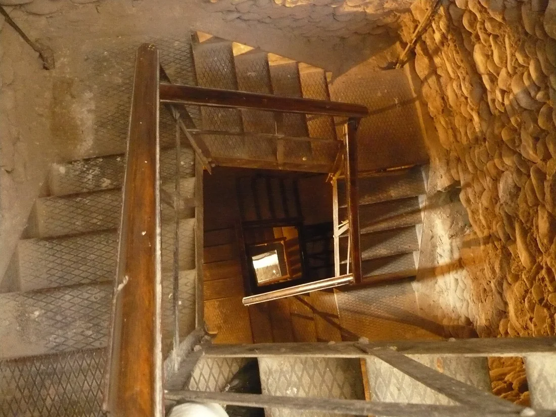 Narrow stone and metal stairs spiralling up inside the Clock Tower