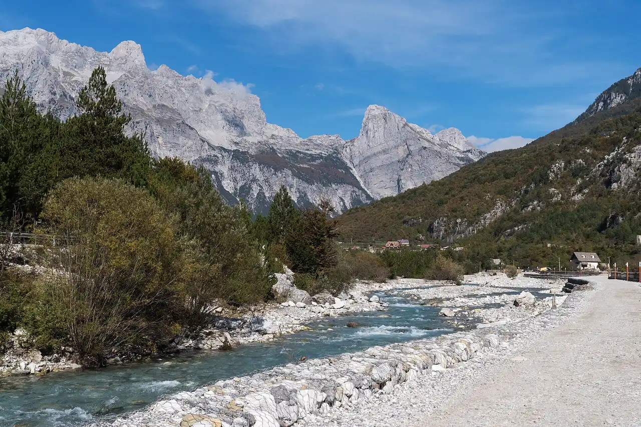 The clear Theth river running over pale stones through the valley floor