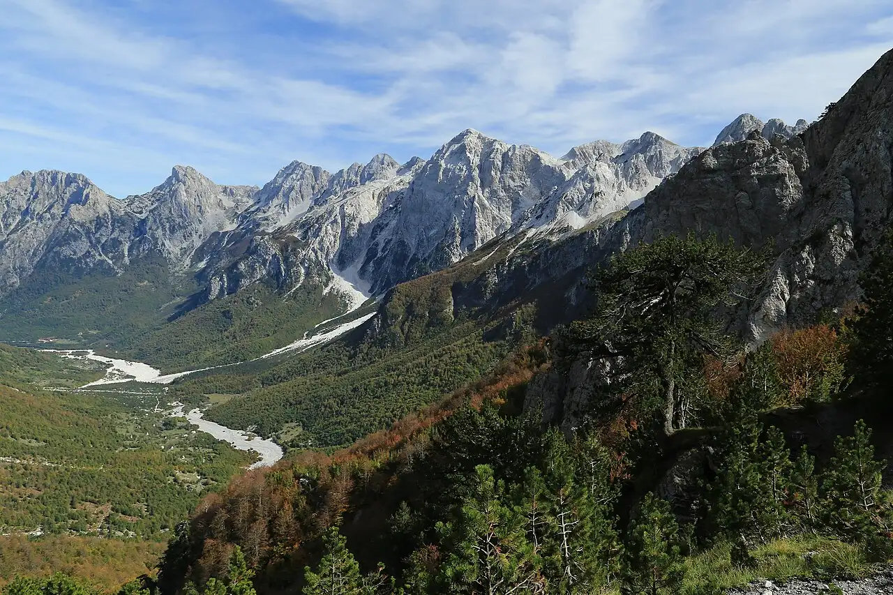 Guesthouses and meadows along the Valbona river below the peaks of the Accursed Mountains