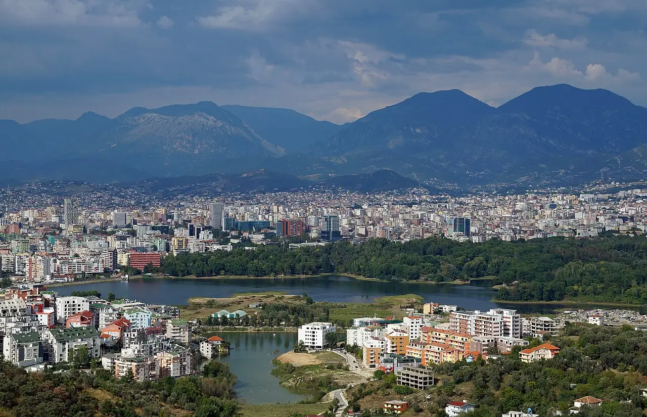 Aerial view of Tirana with the artificial lake and the mountains beyond