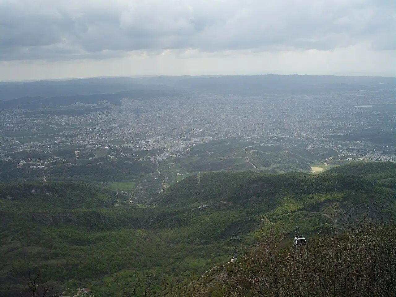 A wide view over Tirana from Mount Dajti with a cable-car gondola in the foreground