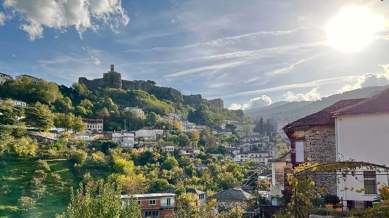 Stone-roofed houses of Gjirokaster climbing the hillside under the castle ridge in southern Albania