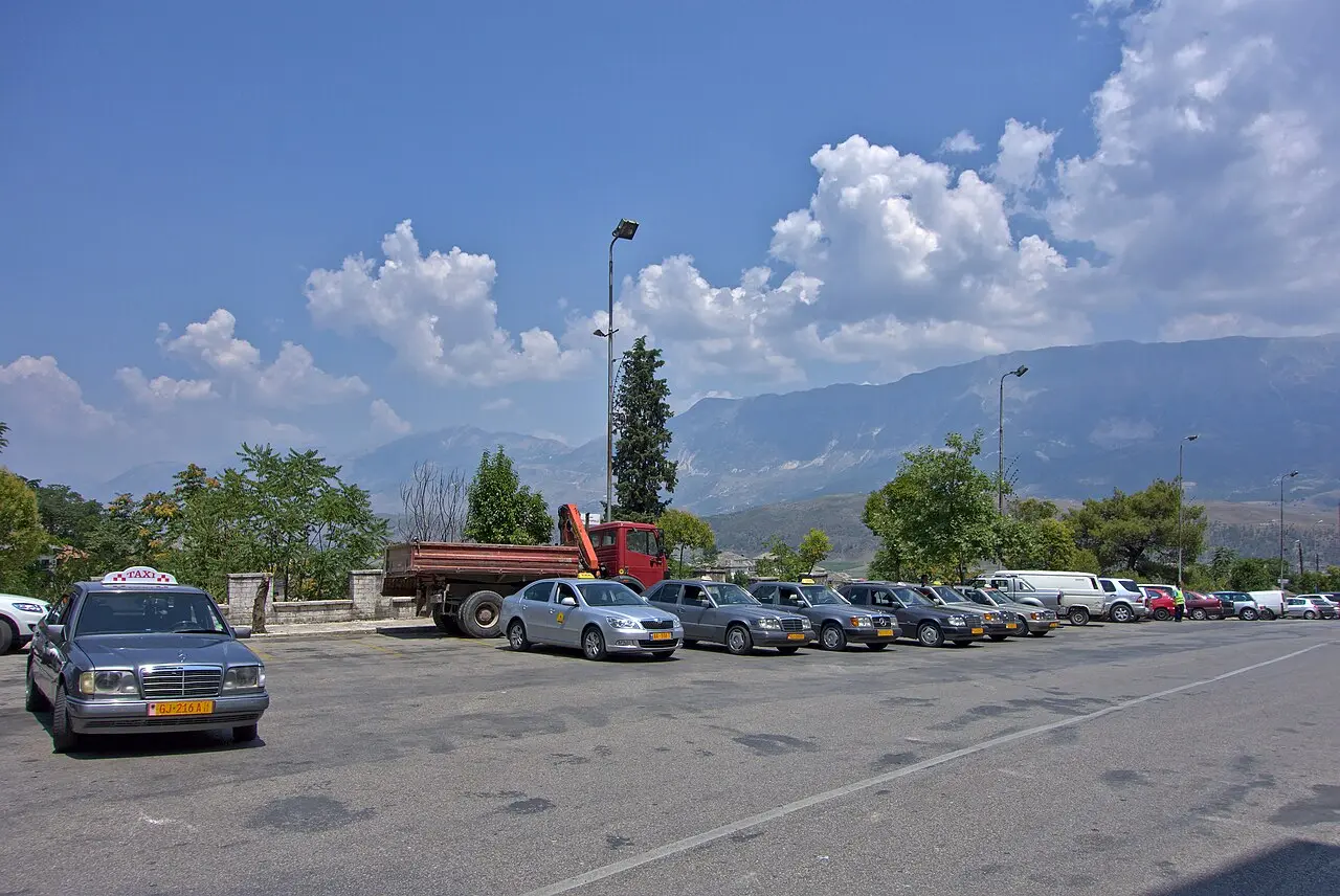 Taxi rank and street below the stone houses of Gjirokaster old town