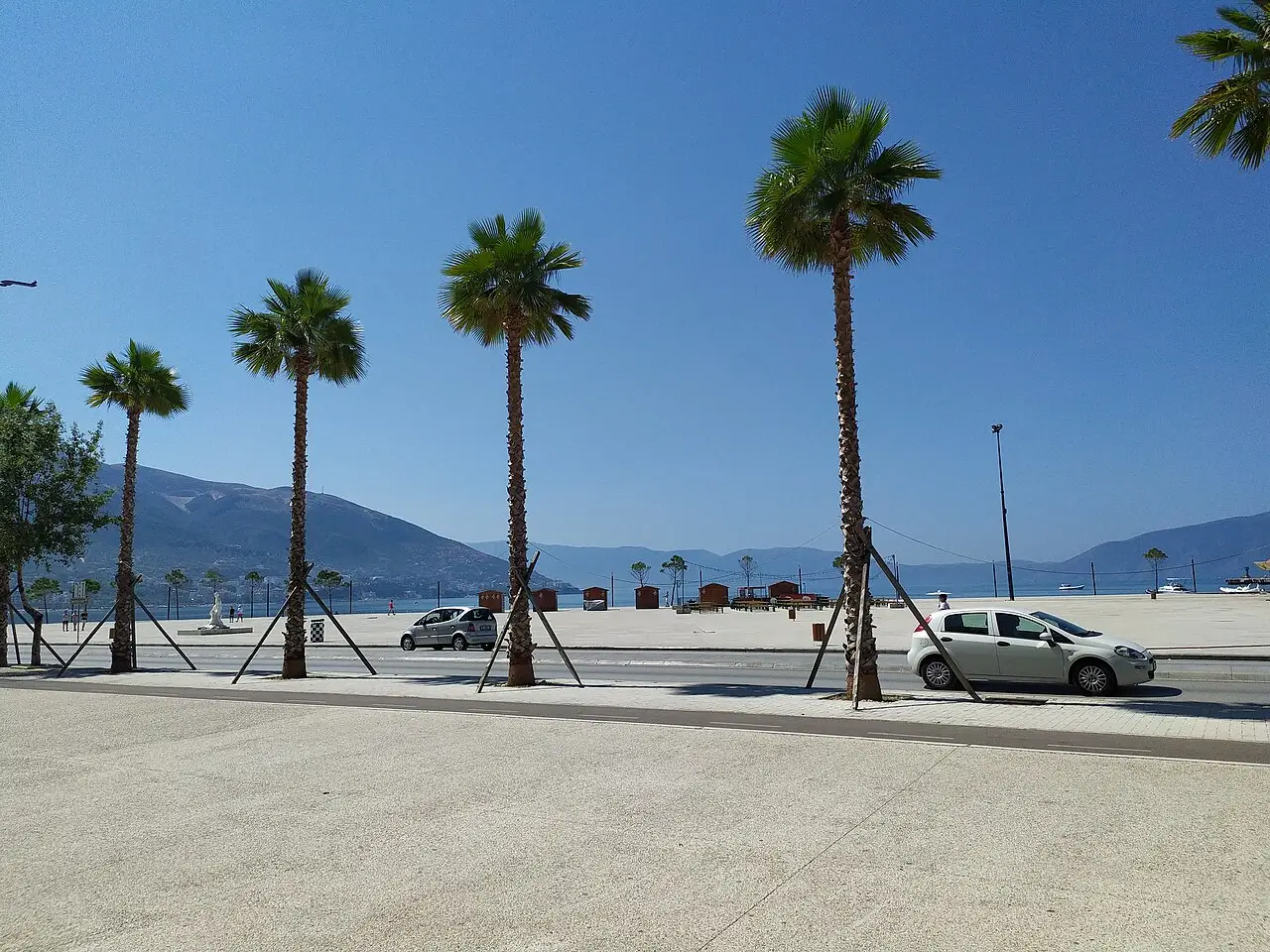 The palm-lined Lungomare seafront boulevard in Vlora with cars and the bay in the background, Albania