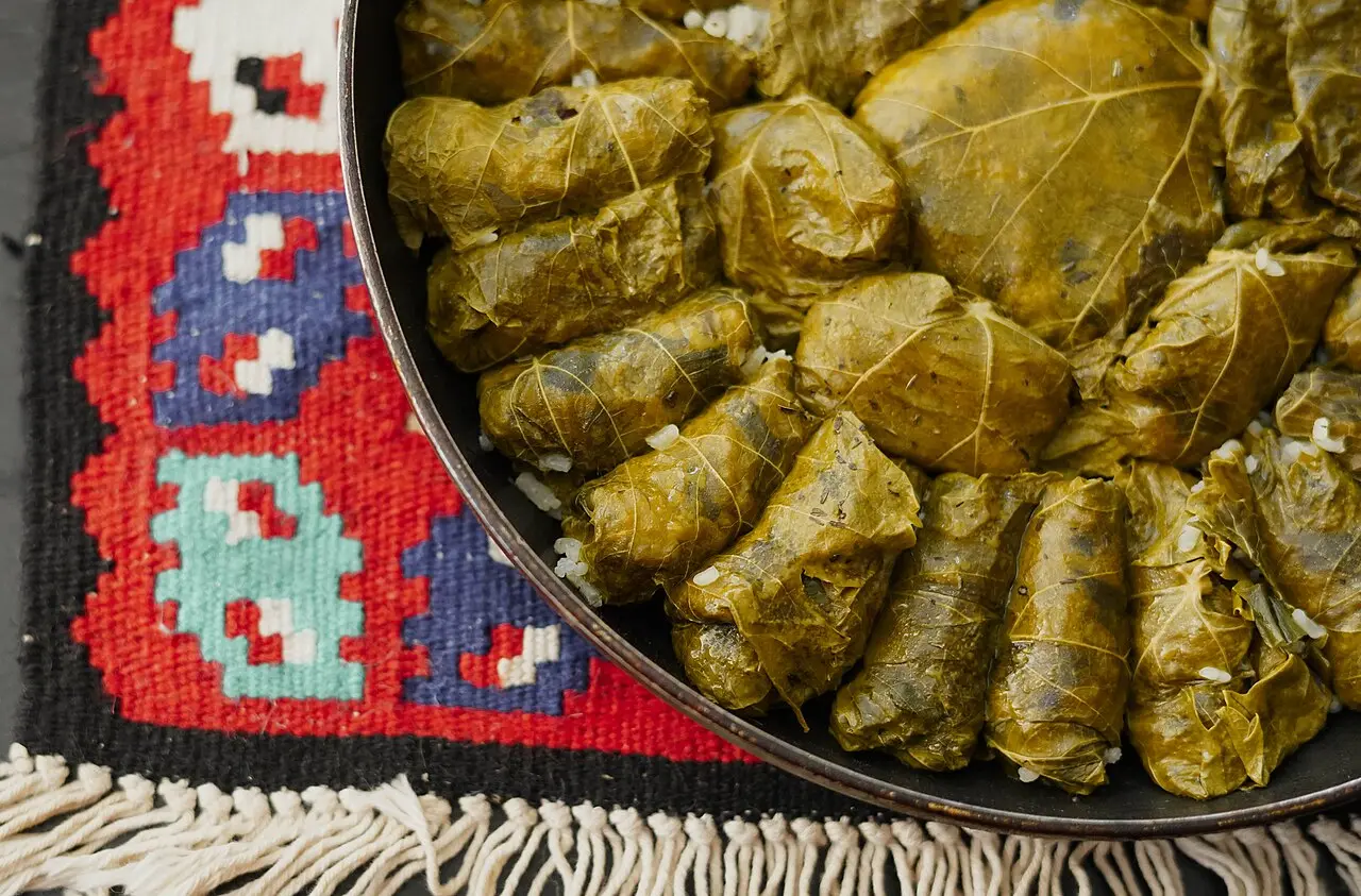 A pan of japrak, stuffed vine leaves, on a red Albanian kilim rug