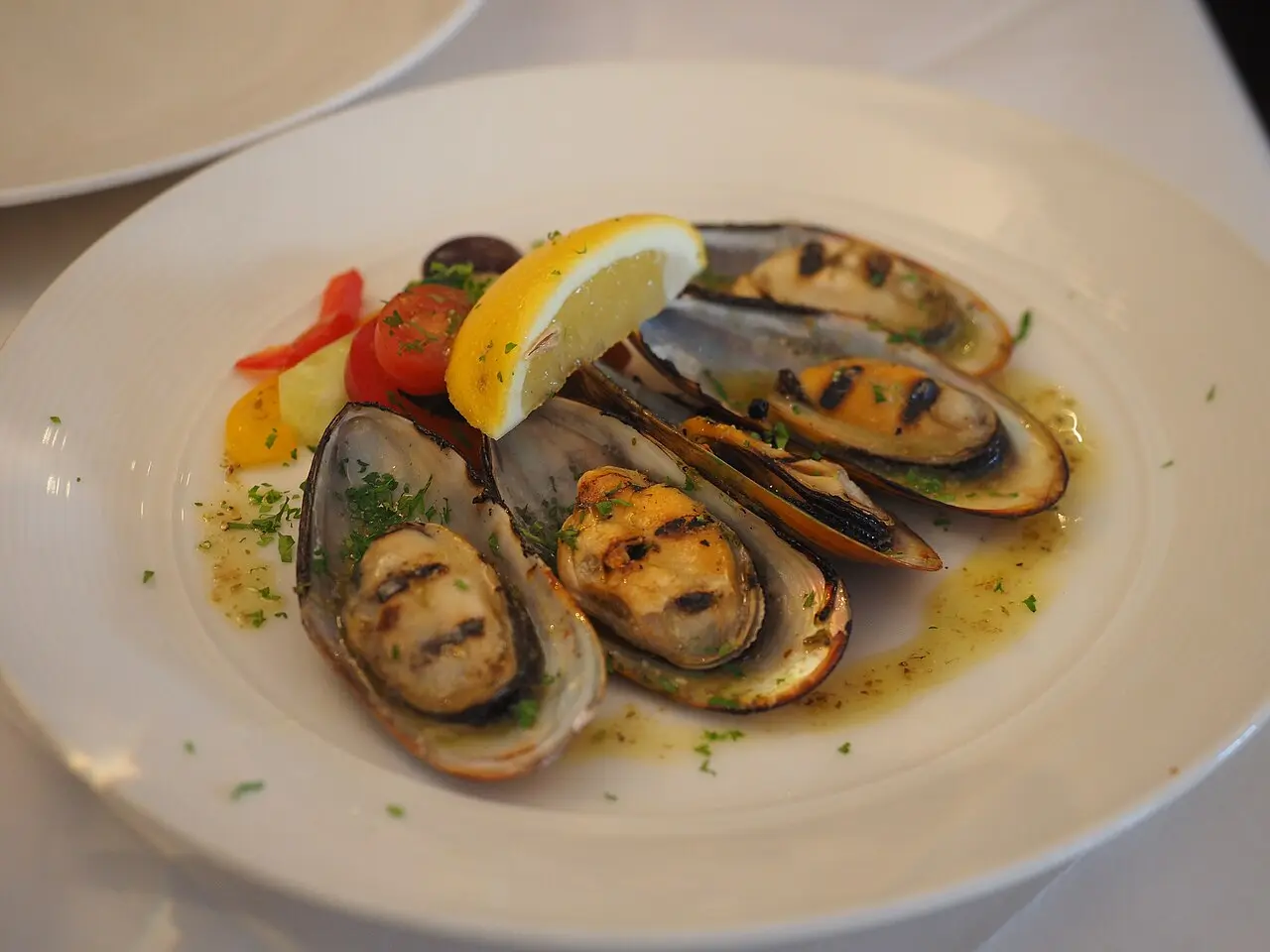 A bowl of cooked mussels in broth, the style served around Lake Butrint