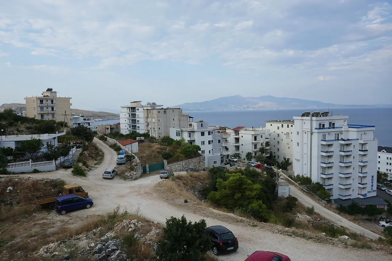 Hotels and apartment blocks on a hillside above Saranda, looking out over the Ionian Sea towards Corfu