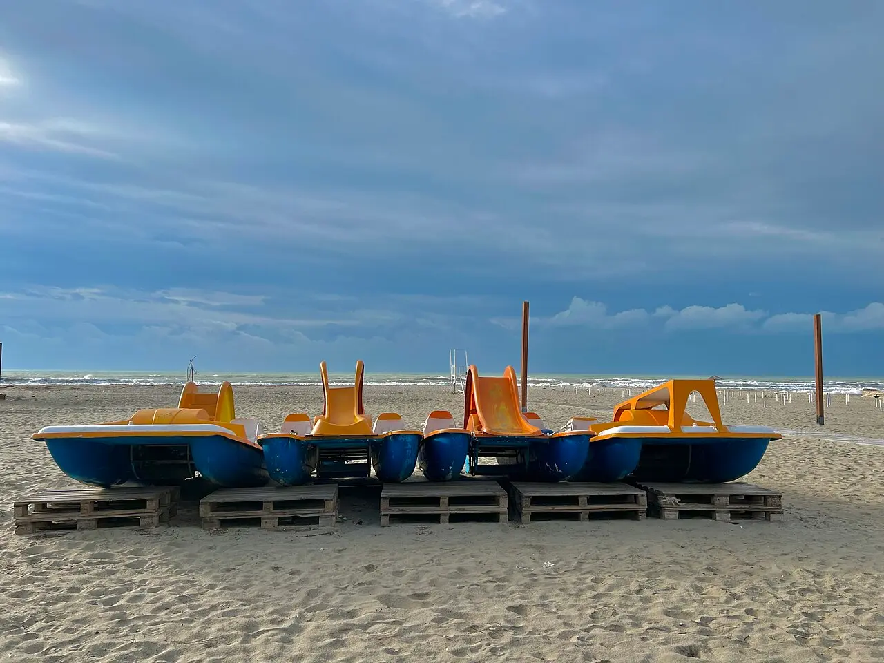Rows of thatched beach umbrellas and seating on the sandy Golem coast