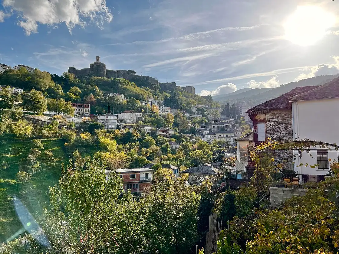 View over slate roofs of Gjirokaster Old Town climbing toward the castle ridge