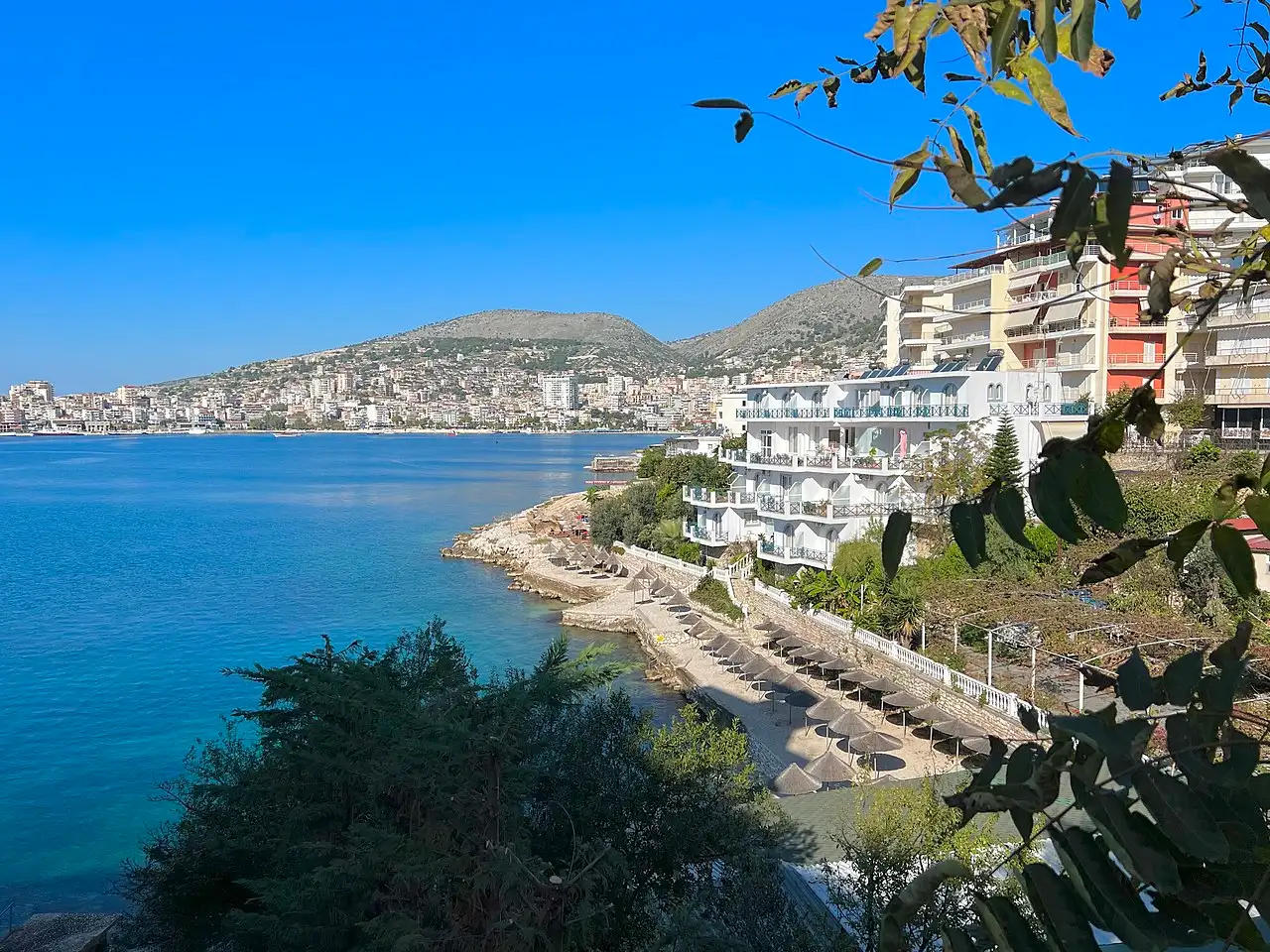 Saranda's waterfront and harbour, with cafes, boats and the town rising behind