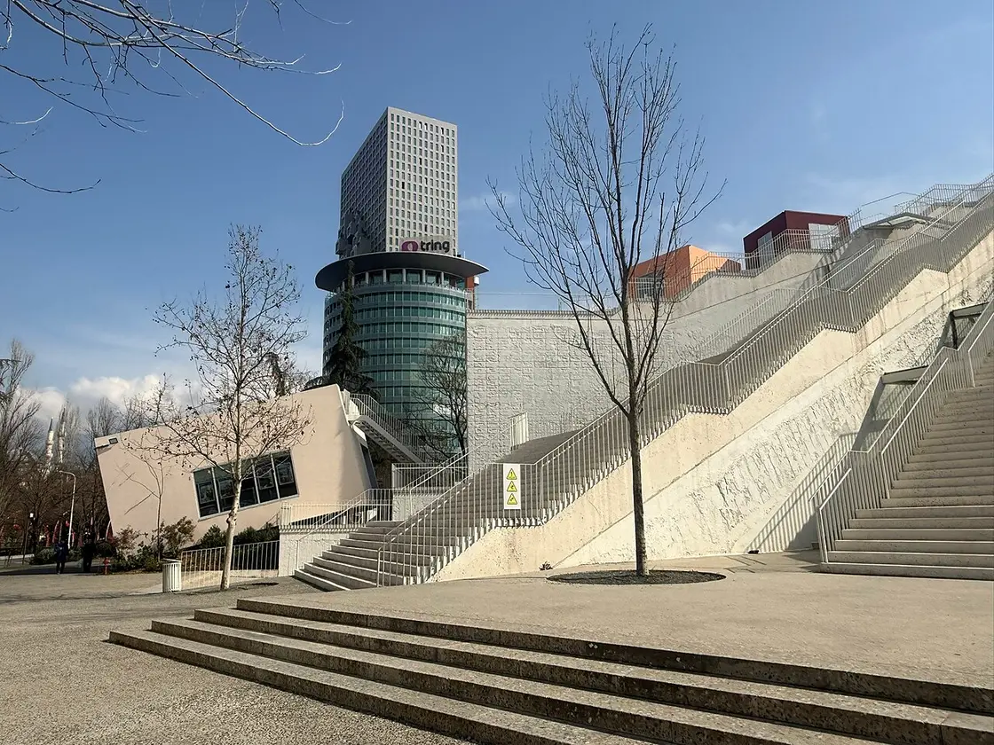 The renovated Pyramid of Tirana's new external staircase, with the MET tower behind