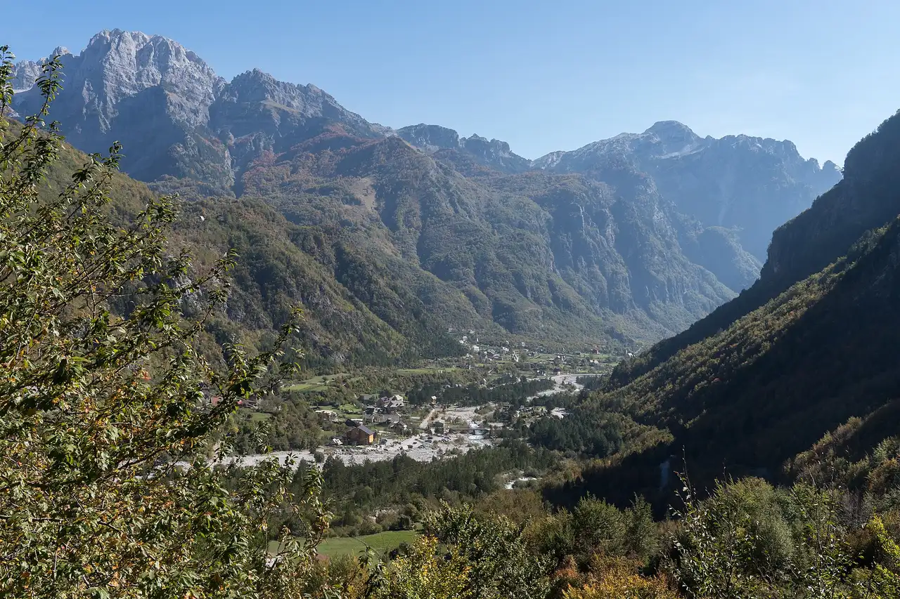 The Theth valley in the Albanian Alps with the village spread along the riverbed below limestone peaks